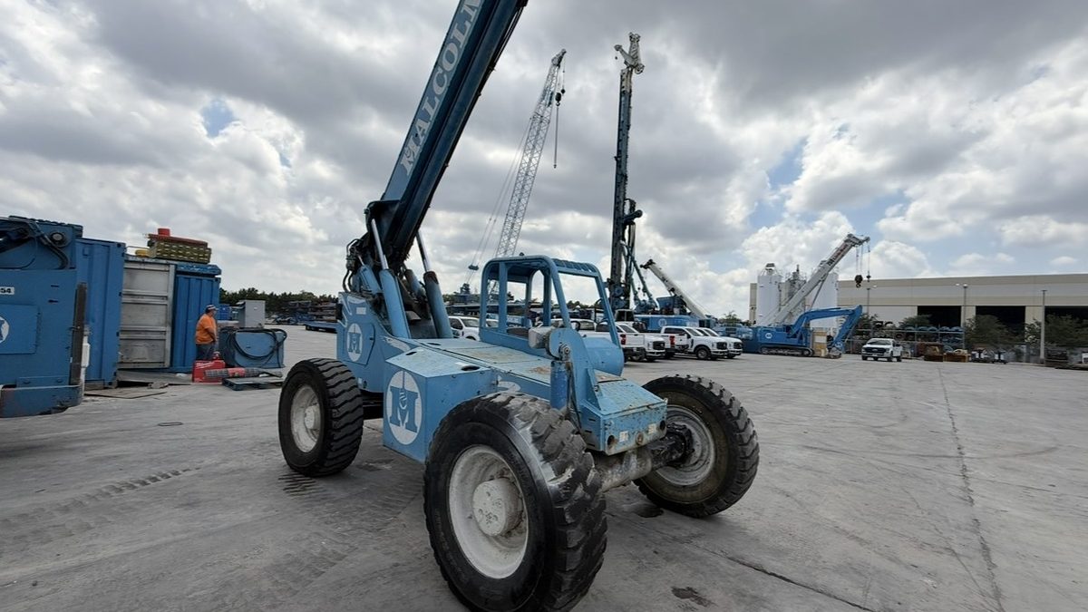 Telehandler telescopic boom forklift with boom extended at an industrial site