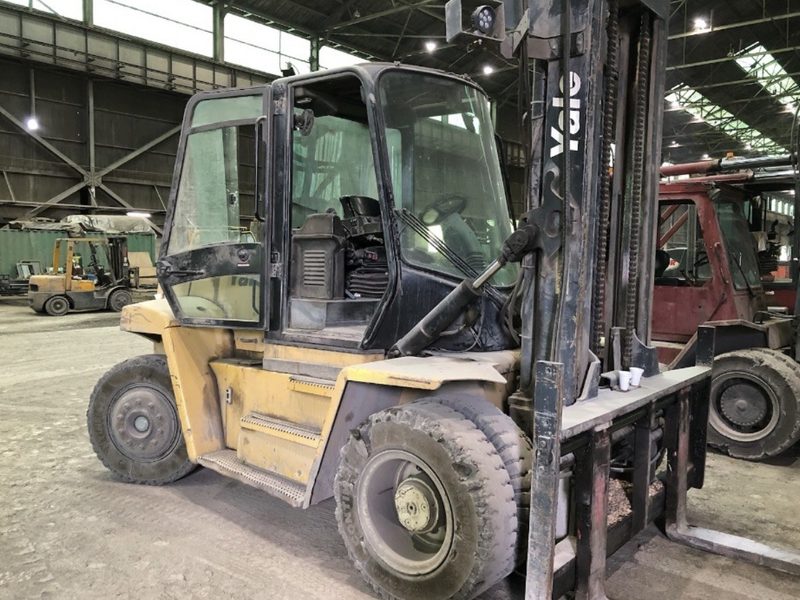 Heavy duty enclosed cab forklift inside a warehouse being evaluated for purchase