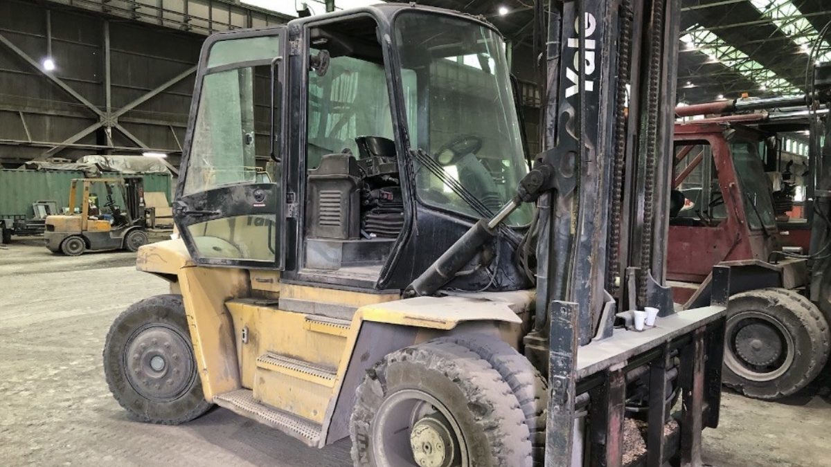 Heavy duty enclosed cab forklift inside a warehouse being evaluated for purchase